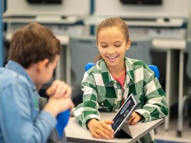 Two students are working at desks