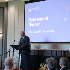 Superintendent Godden stands on stage to welcome guests as the MC