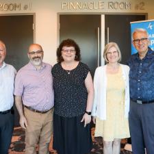 Male Principal stands with two female retirees and their two male guests