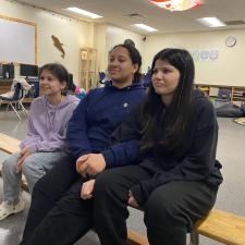 3 Female students sitting on a bench.