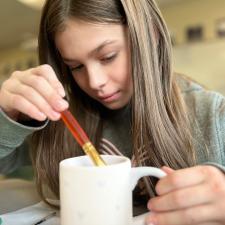 Female student painting a mug